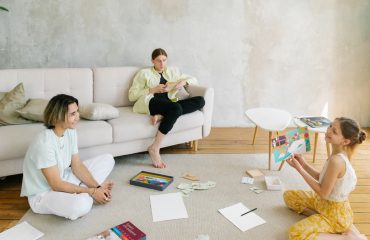 A family enjoying creative activities together in a bright living room setting.